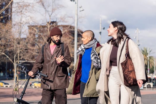 three young friends talking while walking through the city, concept of friendship and modern urban lifestyle, copy space for text