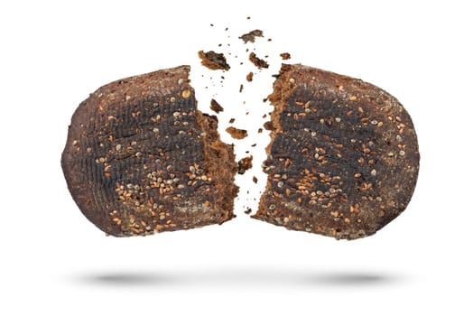 Loaf of black bread on a white isolated background. The bread is broken into 2 parts, crumbs are pouring out of it. Bottom view