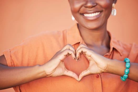 Heart, love and black woman hands for beauty, african self care and fashion cosmetics with peace, happiness and smile with teeth. Summer, orange wall background and happy woman with self love sign.