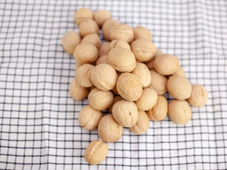 A lot of whole walnuts on a napkin close-up. Healthy, organic and healthy food with a high content of protein and protein.