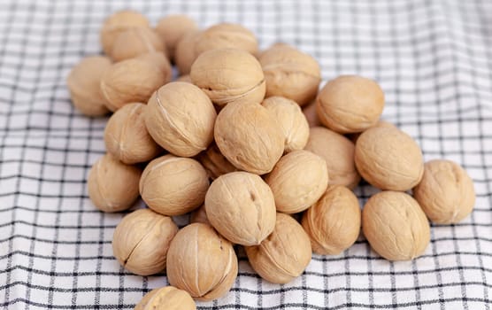 A lot of whole walnuts on a napkin close-up. Healthy, organic and healthy food with a high content of protein and protein.