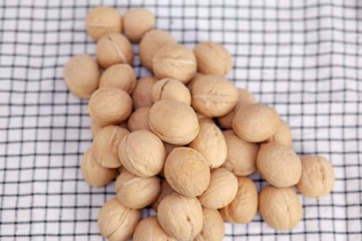 A lot of whole walnuts on a napkin close-up. Healthy, organic and healthy food with a high content of protein and protein.