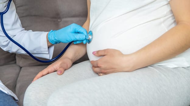 The doctor examines the belly of a pregnant woman. Selective focus. medicine.