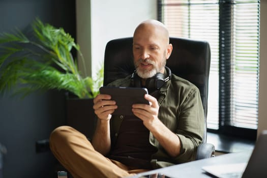 Mature man without job indulging in gaming addiction, spending his life immersed in virtual world of online games on laptop. Concept of idleness and unproductivity. High quality photo