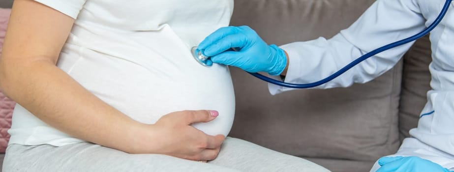 The doctor examines the belly of a pregnant woman. Selective focus. medicine.