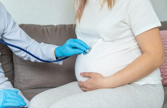 The doctor examines the belly of a pregnant woman. Selective focus. medicine.