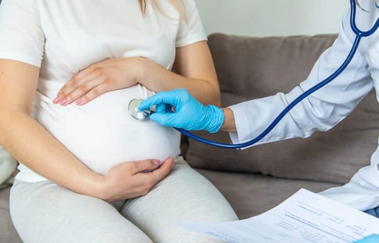 The doctor examines the belly of a pregnant woman. Selective focus. medicine.