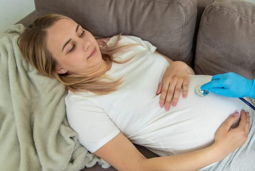 The doctor examines the belly of a pregnant woman. Selective focus. medicine.