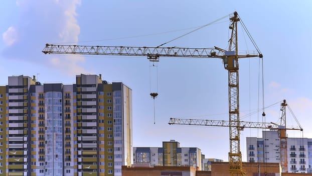 Panoramic view of construction sites and many cranes working in a new construction business.