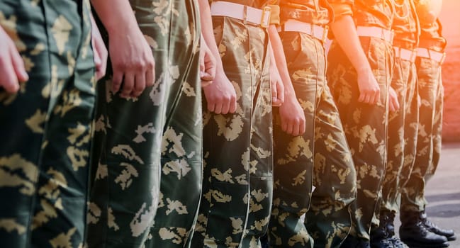 Russian military detachment of border guards stands on the street. Hands and boots close-up.