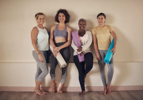 We love doing yoga together. Full length portrait of a young group of woman sitting together and bonding during an indoor yoga session