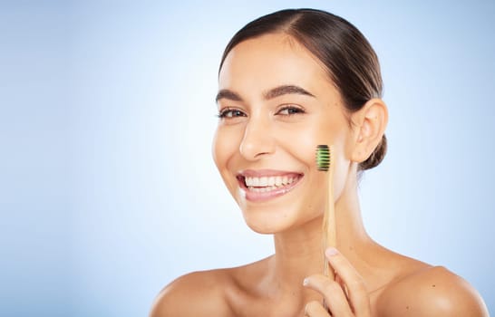 Face portrait, dental and woman with toothbrush in studio isolated on a blue background. Oral wellness, veneers and happy female model holding product for brushing teeth, cleaning and oral hygiene