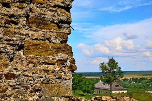 a strip of empty space bearing a slogan or design, hung in a public place or carried in a demonstration or procession. An old fortress wall from stacked stones with a spacious landscape.