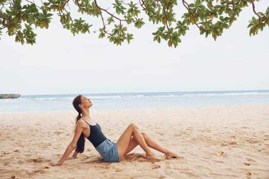 woman beach freedom sea nature vacation water attractive pretty travel sun body smile sitting young adult coast sand relax fashion lifestyle