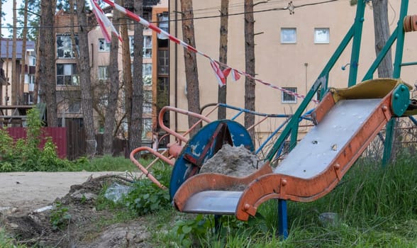 War in Ukraine. Destroyed playground in the city center. The ruins of a high-rise building destroyed by a Russian missile a year after the occupation