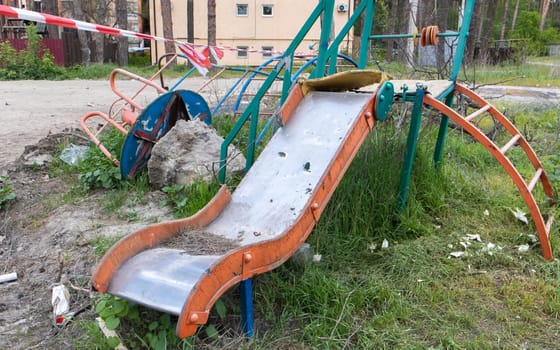 War in Ukraine. Destroyed playground in the city center. The ruins of a high-rise building destroyed by a Russian missile a year after the occupation