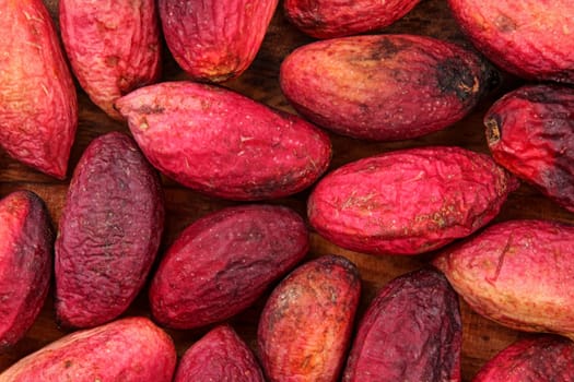 Top view closeup of raw turkish red pistachios, skin wrinkled after couple of days. Nuts and green seeds are under.