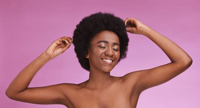 Black woman touching afro hairstyle on beauty studio background in relax skincare, texture maintenance or salon wellness. Model, natural and hair growth, hands on isolated pink or makeup backdrop.