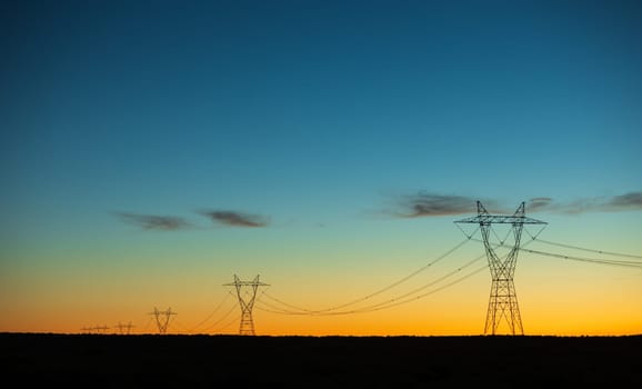 Electricity pylons at orange sunset