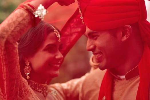 Wedding, romance and red veil with a couple together in celebration of love at a ceremony. Happy, marriage or islam with a hindu bride and groom getting married outdoor in tradition of their culture.