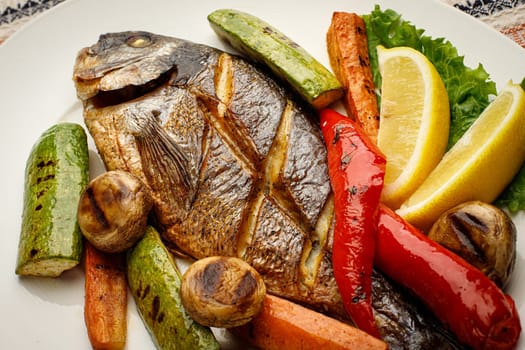 Whole fried fish in a white plate with lemon