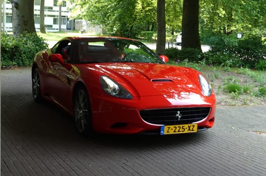 Amersfoort, Netherlands - May 21 2023 A red Ferrari F12 Berlinetta stands in front of a hotel in the Netherlands.