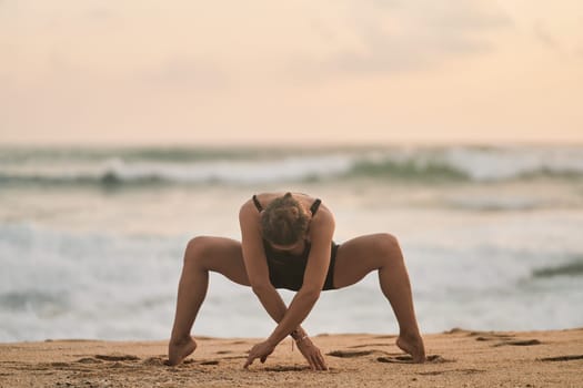 Beautiful girl doing yoga at the beach. High quality photo