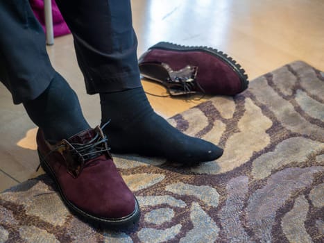 unrecognizable woman in the shop trying new shoes. Caucasian woman sitting in a shoe store while chooses new pair of italian sneakers.