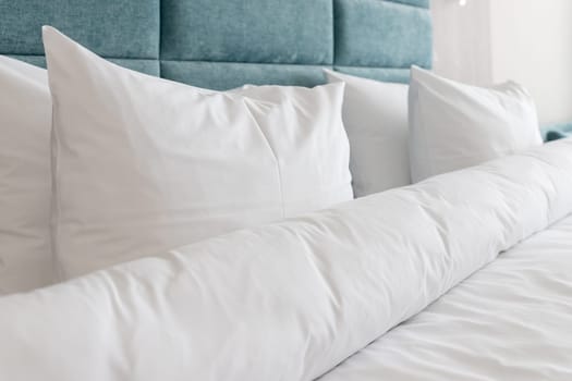Interior with white bed linen on the sofa. Bedroom with bed, white bedding, and bedside table.