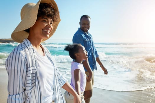 Happy family, summer and beach walk by parents and child on vacation or holiday at the ocean or sea. Travel, mother and father with African daughter or kid holding hands together near water.