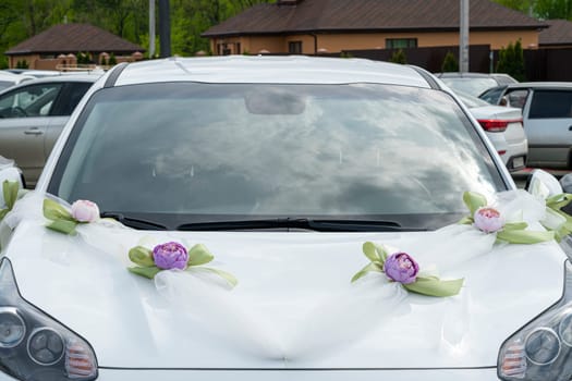 white wedding car decorated with flowers and ribbons close-up. photo