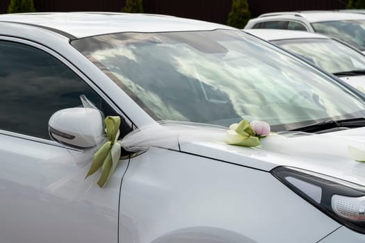 white wedding car decorated with flowers and ribbons close-up. photo