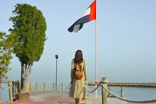Girl on the beach posing against the backdrop of the UAE flag in Dubai