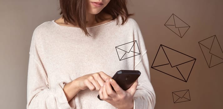 Young girl holds a smartphone in her hands and sends emails to friends, customers. Woman develops her business and communicates with people online, stylized letters are drawn over the mobile phone.