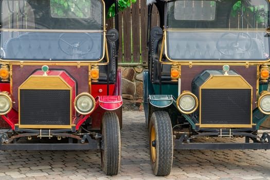 two retro cars close-up on the background of a wooden fence. photo