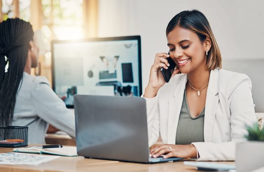 Phone, laptop and communication with a woman graphic designer talking on a call in her office. Computer, creative and design with a female employee working on a project or website at her desk.