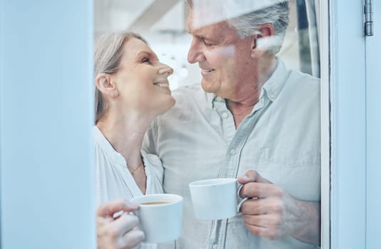 Retirement, coffee and love with a senior couple drinking or enjoying a beverage together in their home. Relax, romance and bonding with an elderly man and woman pensioner by a door in their house.