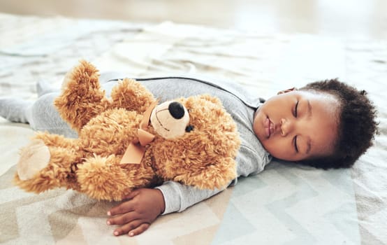 Shot of a baby boy asleep with his teddy bear in his arm.