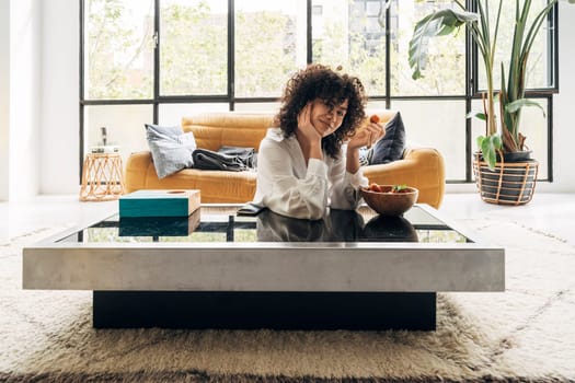 Smiling Pretty African american Young woman looking at camera eating a strawberry. Home concept. Health concept.