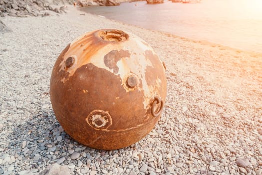 Old rusty sea mine on the beach.