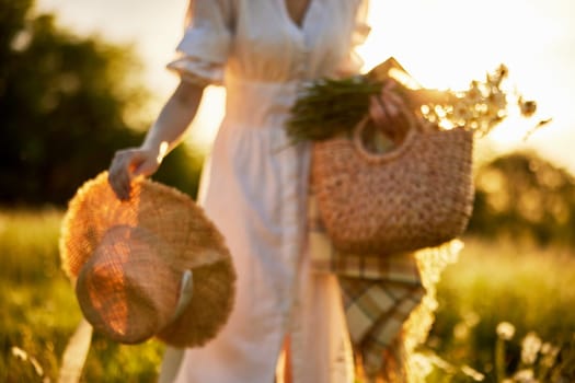 a woman in a light dress in nature with a basket and a wicker hat in defocus. High quality photo