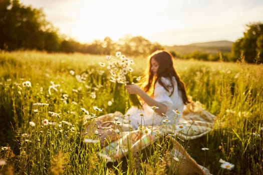 woman sitting in a field with daisies in a light dress out of focus. High quality photo