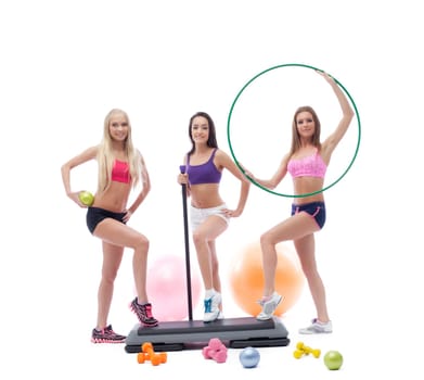 Three cute female athletes posing with sports equipment, isolated on white