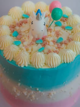 preparing frosted pink blue cup cake with meringue, sweet sprinkles and unicorn topping