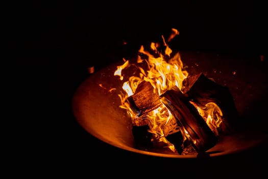 big bonfire in an old rusty fire bowl used for decoration a party.
