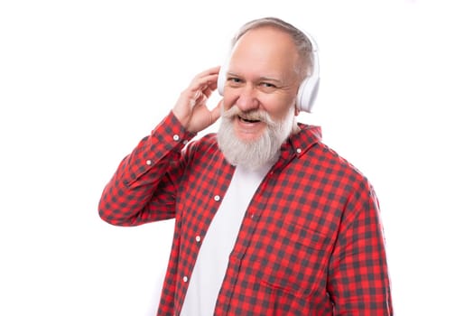 modern music lover 60s middle-aged mature man in a stylish shirt listens to new music in headphones.