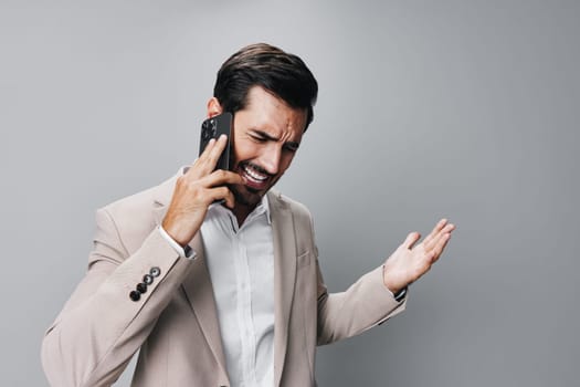man angry handsome business trading hold call portrait entrepreneur white message smartphone smile cell phone male beige suit connection online businessman