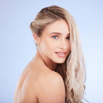 Beauty, hair care and face portrait of woman in studio isolated on a blue background. Cosmetics, keratin and happy young female model with salon treatment for hairstyle, blonde balayage and growth