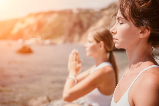 Woman sea yoga. Back view of free calm happy satisfied woman with long hair standing on top rock with yoga position against of sky by the sea. Healthy lifestyle outdoors in nature, fitness concept.