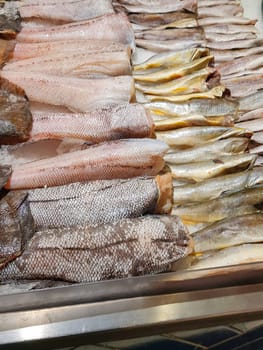 Food background close-up. There are many varieties of fresh fish on the ice lying in a row. Sale of fresh frozen fish at the fish market.